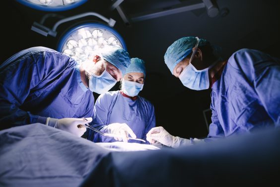 Group of surgeons doing surgery in hospital Group of surgeons doing surgery in hospital operating theater. Medical team doing critical operation.